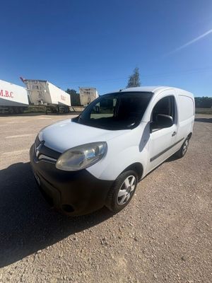 the white van is parked in a parking lot near a building