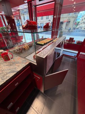un comptoir avec une tasse de café et une vitrine de viennoiseries