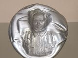 une photo d'une sculpture en argent représentant une femme, posée sur une table