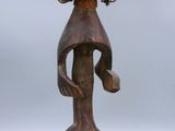 a wooden statue of a woman with a hat on her head