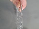 a person holding a piece of clear plastic over a sink