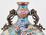 a vase that has a dragon handle on it