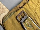 an old belt with a flower design on it sitting on top of a piece of cloth