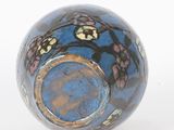 a blue vase with a black and gold design on it