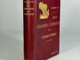 an old book sitting on a white surface with a red cover