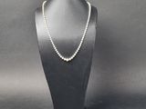 un collier de perles blanches sur un mannequin noir