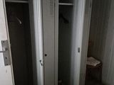 two closets in the corner of a room with a toilet in it