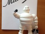 une figurine représentant un homme tenant une bouteille de vin devant une pancarte sur laquelle est écrit « Michel »