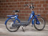 a blue bike parked in front of a brick wall