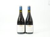deux bouteilles de vin rouge posées sur une table blanche