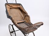 an old fashioned stroller with a basket on the back