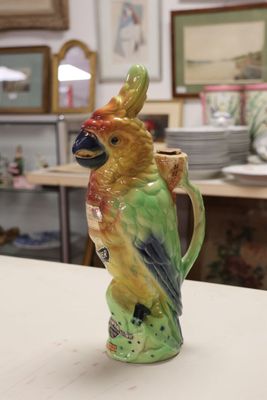 a ceramic bird that is sitting on top of a coffee cup