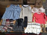 une table sur laquelle sont posés de nombreux vêtements et chaussures