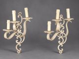 a pair of carved iron sconces with candles on them