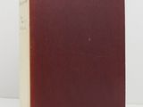 a red book sitting on top of a table next to a white wall