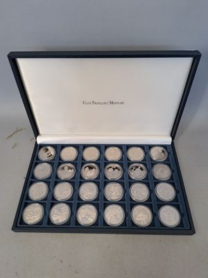 une boîte de pièces d'argent dans un écrin noir posé sur une table