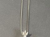 a diamond flower pendant on a chain on a table