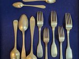 de nombreuses cuillères et fourchettes en argent sur un fond bleu