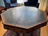 une table avec un plateau en cuir dans un salon