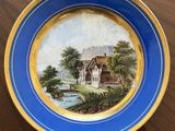 an image of a plate with a painting on it sitting on a table