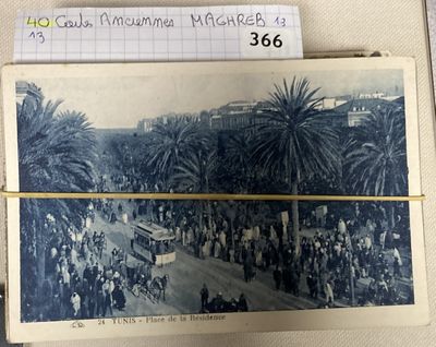 an old photo of a group of people walking down a street