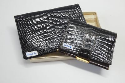 deux portefeuilles en cuir de crocodile noir dans une boîte