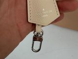 someone is holding a leather keychain with a leather tag attached to it