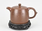 an image of a brown teapot on a stand with chinese writing on it