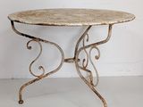 wrought iron table with a marble top and scrollly legs