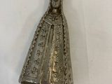 an old silver bell with a statue of the virgin mary on it