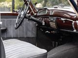 dashboard of a classic car with the door open and the driver ' s seat up