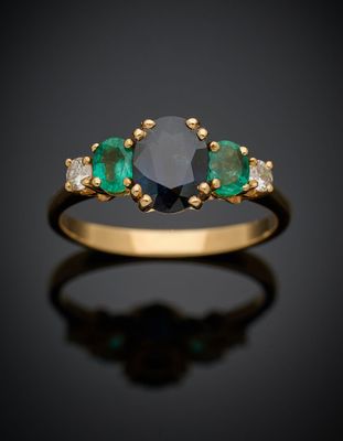 une bague sertie d'un diamant noir et d'une émeraude sur fond noir
