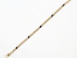 un bracelet en chaîne dorée orné de pierres noires sur fond blanc