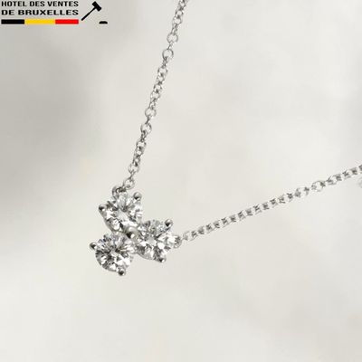 a silver necklace with a diamond flower on it