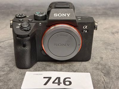 un appareil photo Sony posé sur une table, à côté d'une étiquette de prix