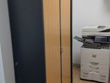 une photo d'un petit bureau avec une imprimante et une armoire
