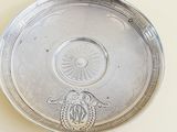 a silver plate with a design on it on a table