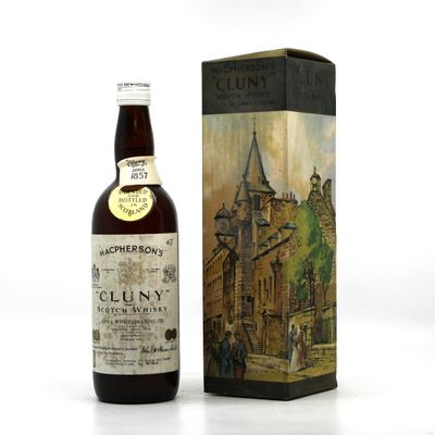 La bouteille de Cluny se trouve à côté d'un carton de vin