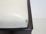 an upholstered white leather chair with a wooden frame and foot rest