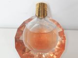 an image of a bottle of perfume sitting on top of a table