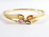 gros plan d'une bague en or avec des pierres multicolores