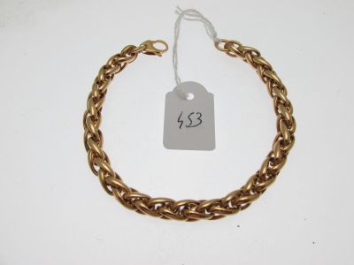 Gros plan sur un bracelet en chaîne en or portant une étiquette