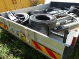 a trailer with a trailer bed full of tires in the grass
