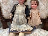 two dolls that are sitting on a chair together
