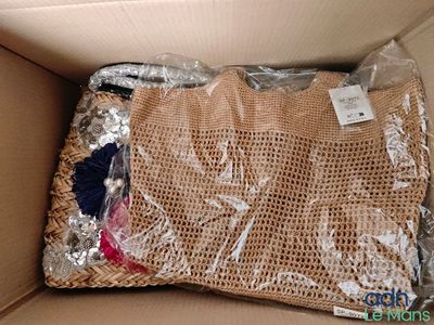 un sac de vêtements dans une boîte sur laquelle est accrochée une étiquette