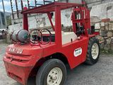 a red forklift truck parked in a parking lot