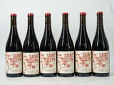 six bottles of wine are lined up on a white surface