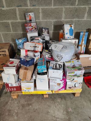 a pile of boxes and boxes on a pallet next to a wall