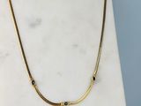 un gros plan d'un collier posé sur une surface en marbre, sur fond bleu