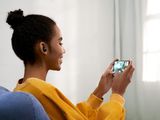 a woman sitting on a couch using a cell phone